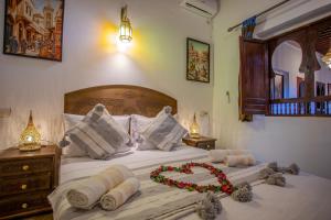 ein Schlafzimmer mit einem Bett mit einem Bett darauf in der Unterkunft RIAD HIKAYA - Born of History in Fès