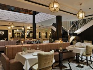 a restaurant with tables and chairs and a staircase at The One Monumental Palace in Porto