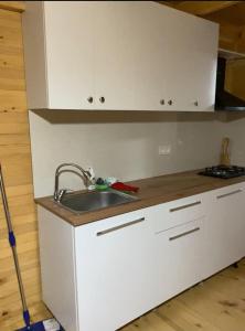 a kitchen with white cabinets and a sink at Nino apartment in Dvabzu