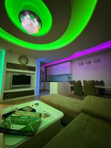 a living room with green lighting and a couch at Duplex in Kosovo Polje
