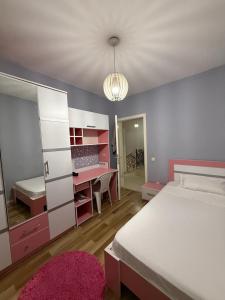 a bedroom with a bed and a room with a desk at Duplex in Kosovo Polje