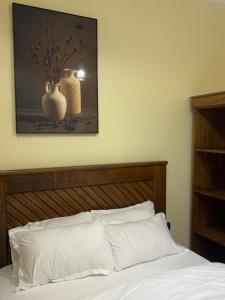 a bedroom with a bed with a vase on the wall at Aiden House Arusha in Arusha