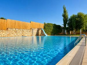 a swimming pool with a waterfall in a resort at Villas El Cañuelo in Monturque
