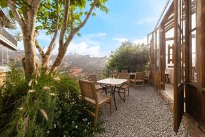 a patio with a table and chairs and a tree at Là Yên Retreat in Ấp Ða Lợi