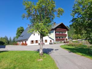 a tree in the middle of a road in front of a building at Bauernhof Ablass in Göstling an der Ybbs