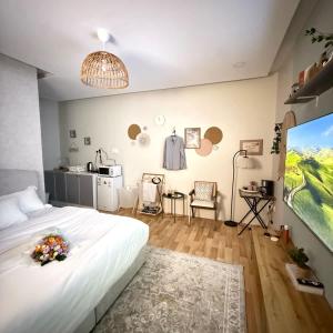 a bedroom with a large white bed and a kitchen at The Italian Studio3 in Dammam