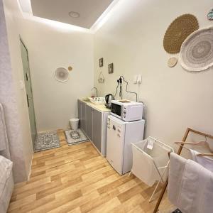 a kitchen with a white refrigerator and a microwave at The Italian Studio3 in Dammam