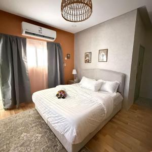 a bedroom with a white bed with a flower on it at The Italian Studio3 in Dammam +24 photos