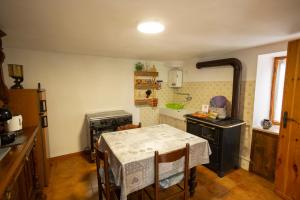 a kitchen with a table and a stove at Baita LA CANAL in Monastero di Lanzo +17 photos