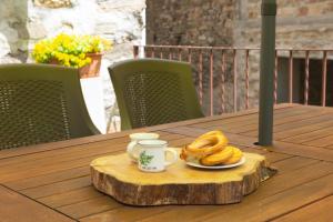 a plate of bagels and a cup of coffee on a wooden table at Baita LA CANAL in Monastero di Lanzo