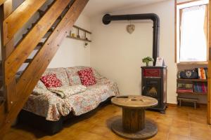 a living room with a couch and a staircase at Baita LA CANAL in Monastero di Lanzo
