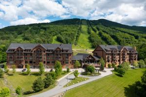 an aerial view of a resort with a mountain in the background at Burke Mountain Hotel in East Burke