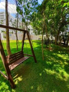 a swing in a park with green grass and trees at Flat com parque aquatico in Rio Quente