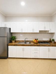 a kitchen with white cabinets and a stainless steel refrigerator at Royal Rif Alhoceima Centre in Al Hoceïma +24 photos