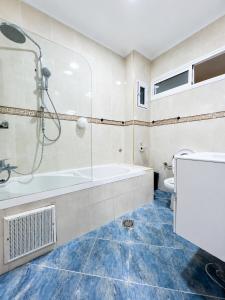a bathroom with a tub and a shower and a toilet at Royal Rif Alhoceima Centre in Al Hoceïma