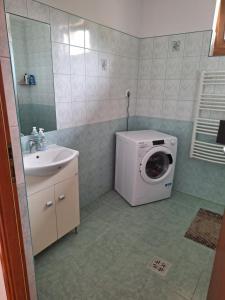 a bathroom with a washing machine and a sink at Veszei Apartman in Békéscsaba