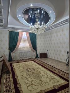 a room with a chandelier and a large rug at Hamroz apartment in Navoi