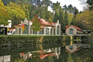 a house next to a body of water at Bungalow Refúgio do Pezo T1 in Melgaço