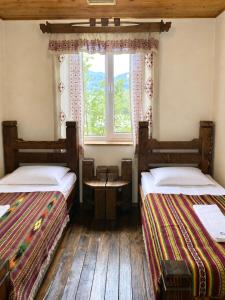 two beds in a room with a window at Stizhok Hotel & Restaurant in Berkhomet-pe-Siret +130 photos