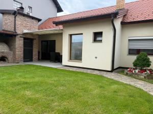 a house with a green lawn in front of it at Apartments Peric - Županja in Županja