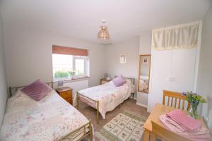 a bedroom with two beds and a window at Avalonia in Glastonbury