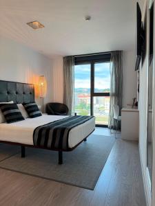 ein Schlafzimmer mit einem großen Bett und einem großen Fenster in der Unterkunft Hotel Noia in Noya + 22 Fotos