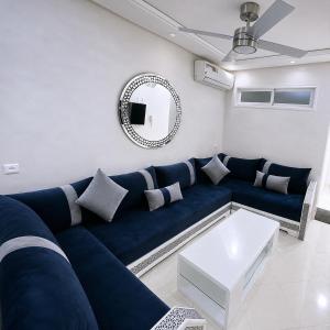a living room with a blue couch and a mirror at Royal Rif Alhoceima Centre in Al Hoceïma