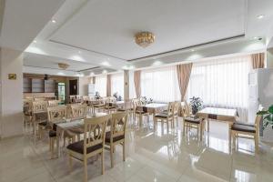 a dining room with tables and chairs and windows at HUMO Hotel in Stantsiya Kyzyl-Tukumachi
