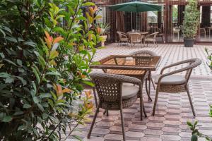 a patio with a table and chairs and an umbrella at HUMO Hotel in Stantsiya Kyzyl-Tukumachi