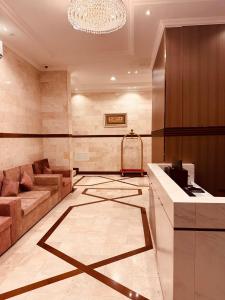 a living room with a couch and a chandelier at Britstar Suites Salalah in Salalah