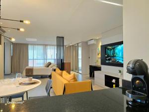 ein Wohnzimmer mit Sofa, Tisch und Fernseher in der Unterkunft Seasons BC in Cabeçudas