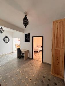 a room with a desk and a bed and a door at Jara Cimrman surf house in Imsouane