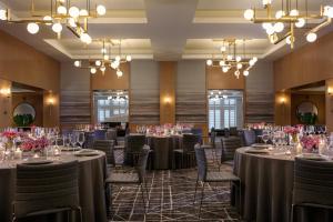 a banquet room with tables and chairs and chandeliers at Kimpton - Harper Hotel by IHG in Fort Worth