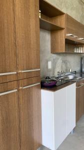 a kitchen with wooden cabinets and a sink at Boutique Loft – Spectacular View – Lake – Mountain in Valle de Bravo