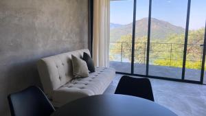 a living room with a couch and a large window at Boutique Loft – Spectacular View – Lake – Mountain in Valle de Bravo