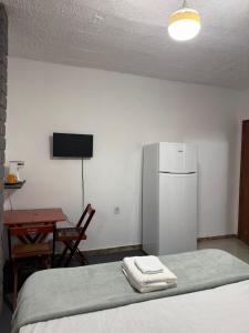 a room with a bed with a refrigerator and a table at Suites Prime in Marataizes
