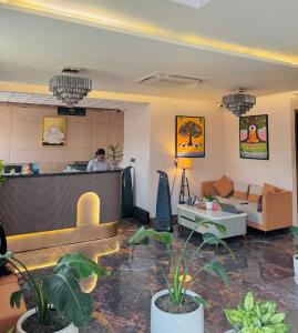 a lobby of a hotel with a man at the counter at Hotel Meridian in Jagādhri