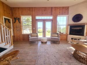 a living room with wood paneling and a fireplace at Brackley Beach Schoolhouse in Brackley Beach
