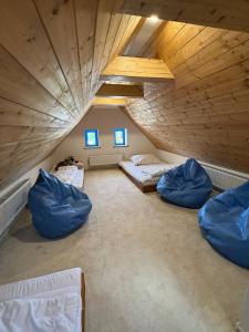 a attic room with three beds and blue pillows at ŠTAJNHAUS DUBICE in Řehlovice
