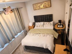 a small bedroom with a bed and a table at Elegant Double Room in Nottingham