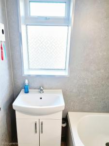 a bathroom with a sink and a window at Elegant Double Room in Nottingham