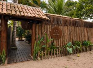 a wooden fence with a sign on it at Zen Spa Caraíva in Caraíva