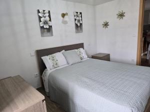 a bedroom with a bed and flowers on the wall at Casa Maria da Eira in Arcos de Valdevez +23 photos