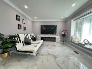a living room with a couch and a tv at Amazing Garden view unit in Toronto