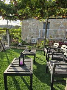 a group of benches sitting on the grass at Casa Maria da Eira in Arcos de Valdevez