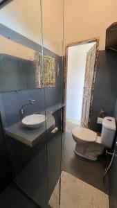 a bathroom with a toilet and a sink and a mirror at Zen Spa Caraíva in Caraíva