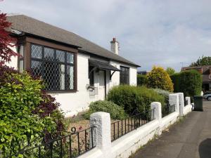 a white house with a fence in front of it at Rose Cottage Edinburgh in Edinburgh
