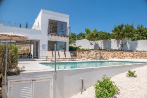 a villa with a swimming pool and a house at Esprit Villas in Polis Chrysochous