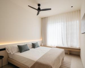 a bedroom with a bed with a ceiling fan at Hostal Serea in Denia