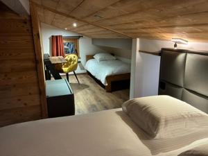 a bedroom with a bed and a chair in a room at Nid des aiguillettes in Chevenoz